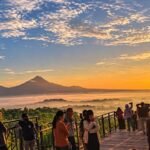 Misty Borobudur sunrise silhouette seen from a nearby hill viewpoint