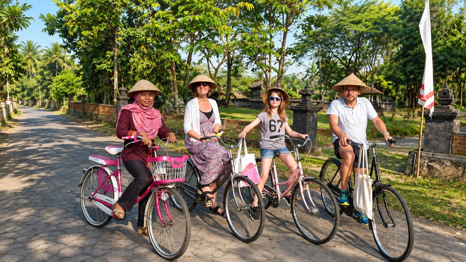 Travelers in straw hats cycling along a quiet village road near Borobudur